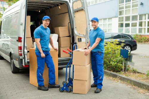 Movers handling desks and IT equipment during a commercial move in Bow